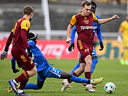 Liberecký zálo�ník Toumani Diakite se sna�í vypíchnout mí� soupe�i z Dukly.