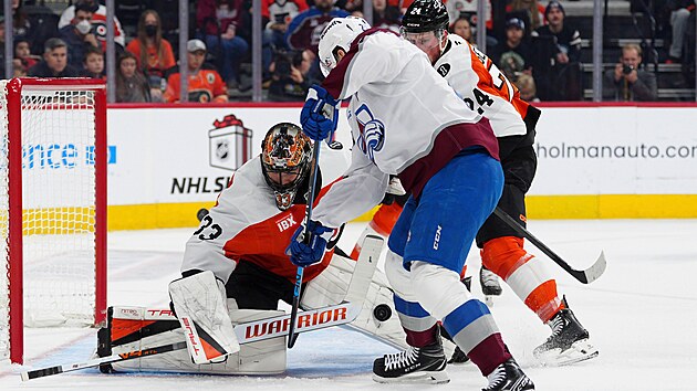 Brank�� Samuel Ersson z Philadelphie zasahuje proti st�ele Nathana MacKinnona z Colorada.