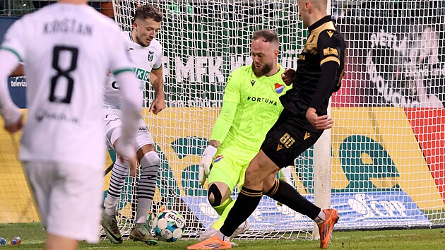 Brank�� fotbalist� ostravsk�ho Ban�ku Dominik Holec si p�ed karvinsk�m z�lo�n�kem Samuelem �igutem hl�d� prostor u prav� ty�e.