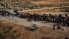 Palestinci sledují mladé lidi jezdící na motorkách a �ty�kolkách po píse�ných...