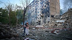 Lidé se objímají poté, co ruská raketa zasáhla bytový dm v Kyjev. (17. ervna...