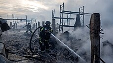 Záchraná�i pracují na míst� skladu, který byl zasa�en b�hem noci ruských...