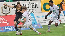 Ostravský obránce Karel Pojezný odehrává mí� p�ed Albertem Labíkem z Karviné....