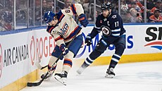 David Tomá�ek brání u mantinelu puk p�ed Adamem Lowrym.