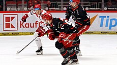 T�inecký úto�ník Mat�j Kubiesa (v bílém) v utkání s Hradcem Králové sleduje puk.