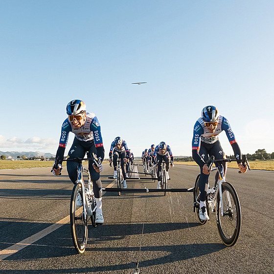 Cyklisté Red Bullu ve sp�e�ení a za nimi letadlo, kterému se díky jejich výkonu...