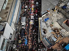 Záb�r z dronu ukazuje smute�ní hosty shromá�d�né kolem t�l, den po smrtící...