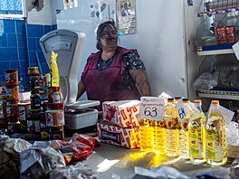 Saze pokrývají tvá� obchodnice, která stojí za svým stánkem n�kolik minut poté,...