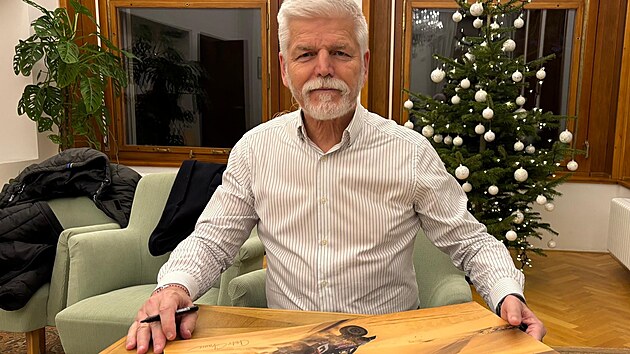 Prezident Petr Pavel podepisuje sv� fotografie, kter� byly v dobro�inn� aukci.