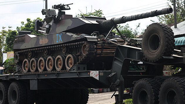 Vojenský nákladní v�z p�evá�í tank po silnici uprost�ed smrtících st�et� mezi...