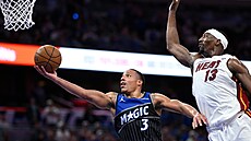 Desmond Bane z Orlando Magic zakon�uje p�ed Bamem Adebayem z Miami Heat v NBA...