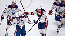 Zach Hyman z Edmontonu (vpravo) a Connor McDavid gratulují Leonu Draisaitlovi k...