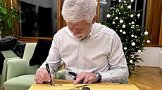 Prezident Petr Pavel podepisuje své fotografie, které jsou v dobro�inné aukci.