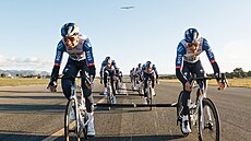 Cyklisté Red Bullu ve speení a za nimi letadlo, kterému se díky jejich výkonu...