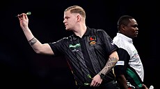 Mike De Decker zam��uje �ipku, za ním prochází soupe� David Munyua.