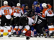 Rozhod�í se sna�í uklidnit poty�ku mezi hrá�i Philadelphie a New Yorku Rangers.