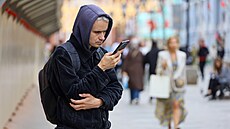 Mu� se dívá do telefonu na ulici v Moskv� (2. zá�í 2025)