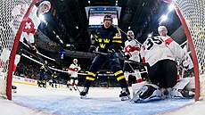 Milton Gästrin ze �védska je zasa�en vysokou holí ve snaze dostat kotou� do...