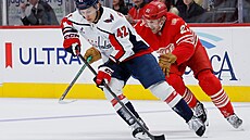 Washingtonský obránce Martin Fehervary s pukem p�ed Jamesem van Riemsdykem z...