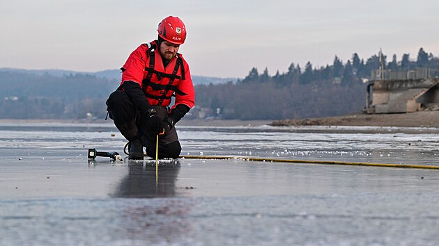 Str�n�k z po���n� jednotky M�stsk� policie Brno Pavel Vrt�na m��� tlou��ku ledu na zamrzl� ��sti Brn�nsk� p�ehrady. (7. ledna 2026)