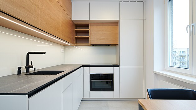 Kuchy�sk� linka je v dekoru b�l� a dubu, dopln�n� o �ernou pracovn� desku z kompaktn�ho lamin�tu. Mezi sk���kami je sklo, op�t odleh�uj�c� prvek, kter� je z�rove� praktick� na �dr�bu.