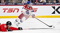 �eský kapitán Petr Sikora si na led pokládá bránícího kanadského obránce Zaynea...