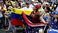 Lidé v americkém stát� Miami mávají venezuelskými vlajkami v reakci na zprávy o...