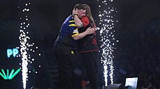 Luke Littler se po výh�e v semifinále mistrovství sv�ta objímá s Ryanem Searlem.