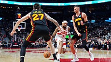 Vít Krej�í a Kristaps Porzingis se sna�í zastavit nájezd Brandona Ingrama.