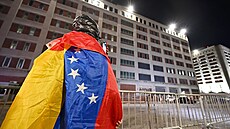 Mu� s venezuelskou vlajkou stojí p�ed Metropolitním deten�ním centrem (MDC) v...