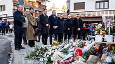 �lov�k nese kv�tiny k provizornímu památníku p�ed barem �Le Constellation� po...