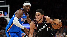 Devin Booker (1) z Phoenix Suns úto�í na ko� Oklahoma City Thunder, brání ho...
