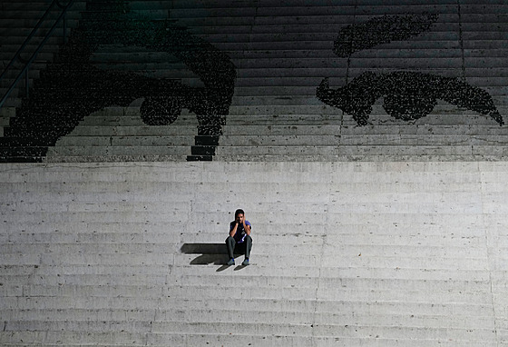Mu� sedí na schodech zdobených nást�nnou malbou p�edstavující o�i zesnulého...