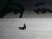 Mu� sedí na schodech zdobených nást�nnou malbou p�edstavující o�i zesnulého...