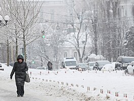 �ena krá�í po zasn�ené ulici v mrazivém zimním ránu v Kyjev�. (15. ledna 2026)