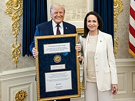 Americký prezident Donald Trump pózuje s medailí, kterou mu p�edala nositelka...