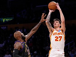 Vít Krej�í z Atlanta Hawks st�ílí na ko� Los Angeles Lakers, brání ho LeBron...