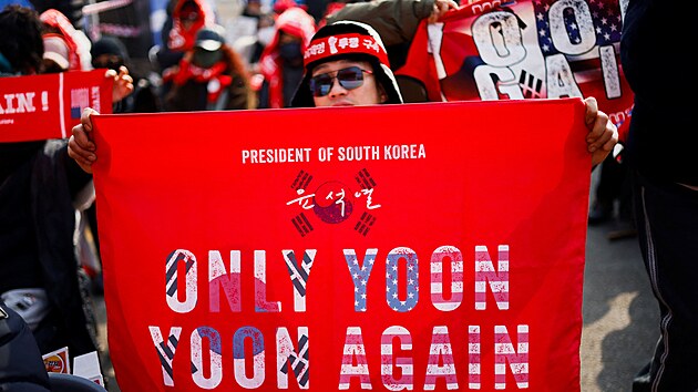 Demonstrant dr�� transparent se sloganem na podporu b�val�ho jihokorejsk�ho prezidenta Jun Sok-jola. (16. ledna 2026)