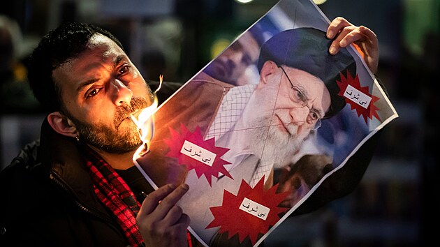 Demonstrant p�l� cigaretou obraz ajatoll�ha Al�ho Chamene�ho b�hem shrom�d�n� na podporu celost�tn�ch masov�ch demonstrac� v �r�nu proti vl�d� v Curychu ve �v�carsku. (13. ledna 2026)