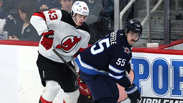 Winnipe�sk� �to�n�k Mark Scheifele si kryje puk p�ed Lukem Hughesem z New Jersey.