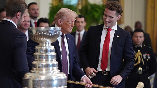 Americk� prezident Donald Trump p�eb�r� zlatou hokejku od hr��� Floridy.