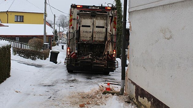 �idi� popel��sk�ho vozu nezvl�dl couv�n� a narazil do domu, kter�mu urazil ��st rohu.