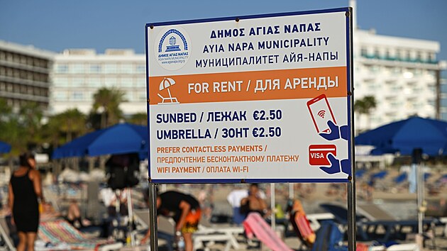 Cedule v �e�tin�, angli�tin� a ru�tin� l�kaj�c� na leh�tka a slune�n�ky k pron�jmu na jedn� z pl�� na Kypru. (18. ��jna 2025)