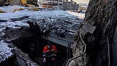 Obyvatel ukazuje noviná�i místo, kde v�era v noci ruský dron zasáhl st�echu...