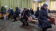 Lidé v Kyjev� se oh�ívají, zatímco �ekají na nabití svých mobil� ve vládním...