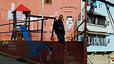 Mu� stojí na d�tském h�i�ti zdobeném graffiti zobrazujícím bývalého...