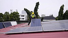 In�enýr spole�nosti Rensource Energy instaluje solární panely na st�echu domu v...