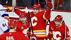 Adam Klapka (uprost�ed) z Calgary slaví se spoluhrá�i svou trefu v zápase proti...