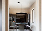 Nad kulatým stolem visí záv�sné svítidlo s výrazným socha�ským charakterem.