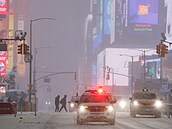 Lidé p�echázejí ulici b�hem sn�ení na Times Square v New Yorku. (25. ledna...
